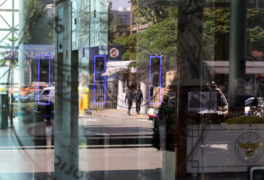 17일 서울 서대문구 미근동 경찰청 유리문에 경찰의 근무 모습이 비쳐 보이고 있다. 경찰청은 검찰이 고(故) 백남기 농민 사망사건 수사결과를 발표하자 "수사결과를 무겁게 받아들인다"며 "백남기 농민과 유족에게 다시 한 번 사과와 함께 심심한 애도를 표한다"고 밝혔다.